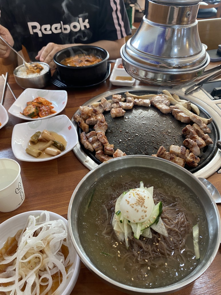 불판 테두리에 둘러앉은 고기와 물냉면.