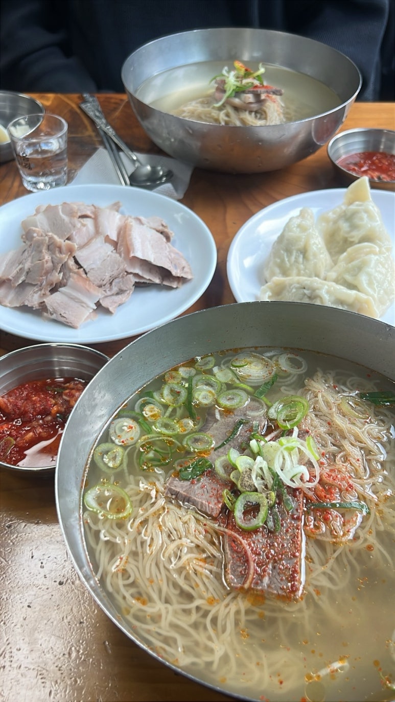 앞에 온면, 뒤에 물냉면이 놓인 식탁