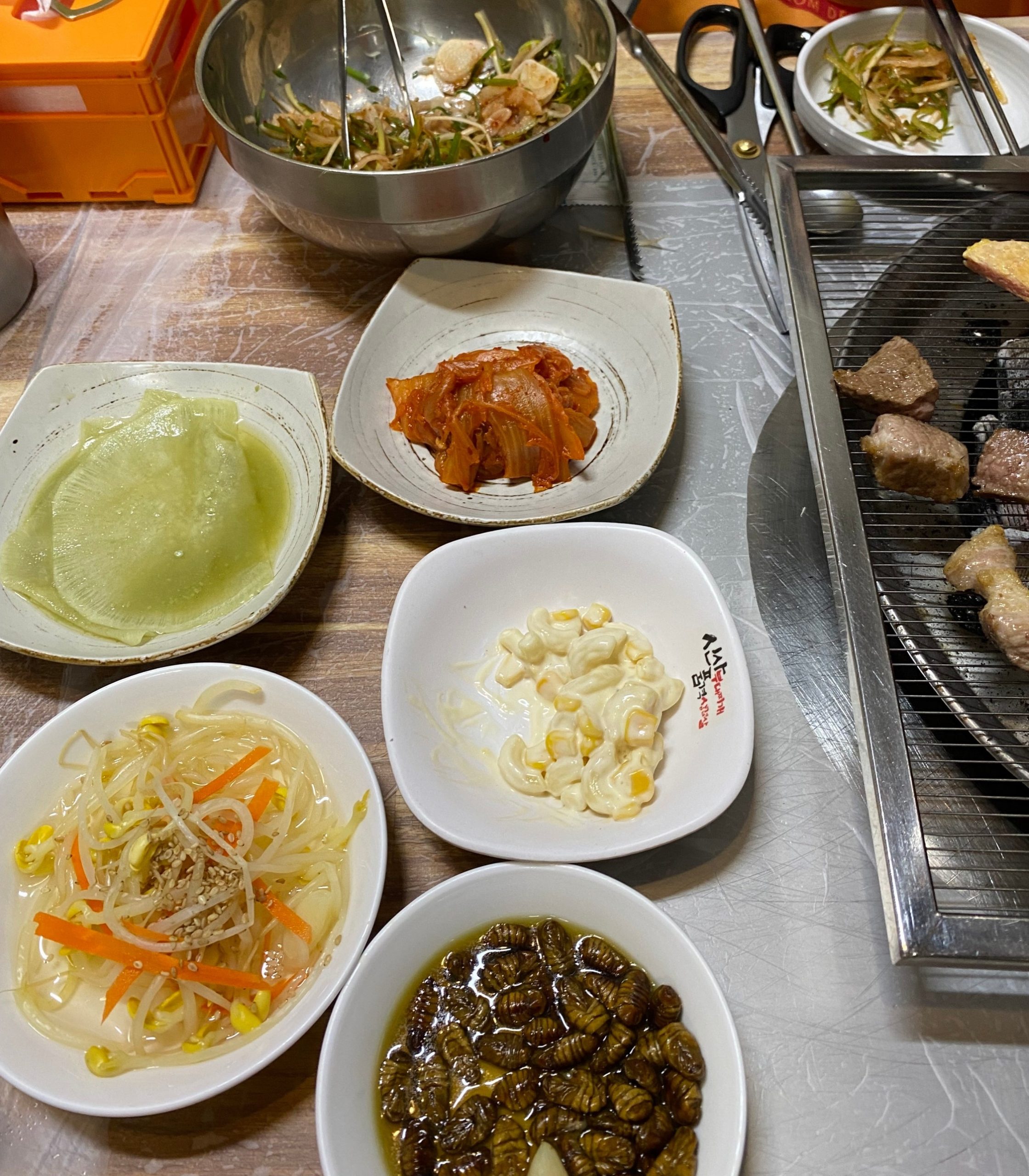 목살과 함께 놓인 반찬과 채소 무침.